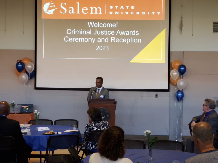 A man stands behind a podium and speaks at the Criminal Justice Award Ceremony.