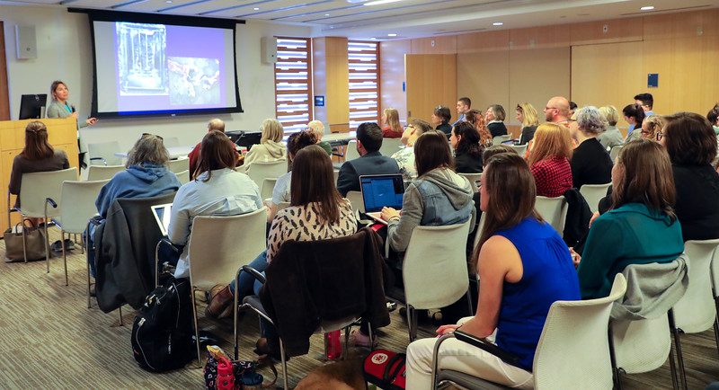 An audience listens to a presentation inside the William Bates Center.