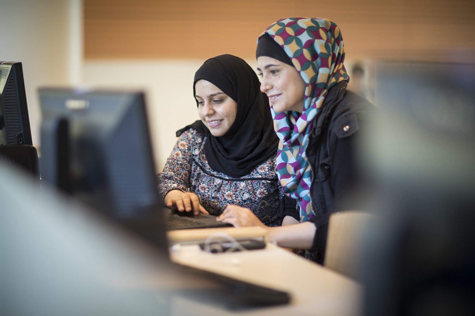 Two students in front of a computer