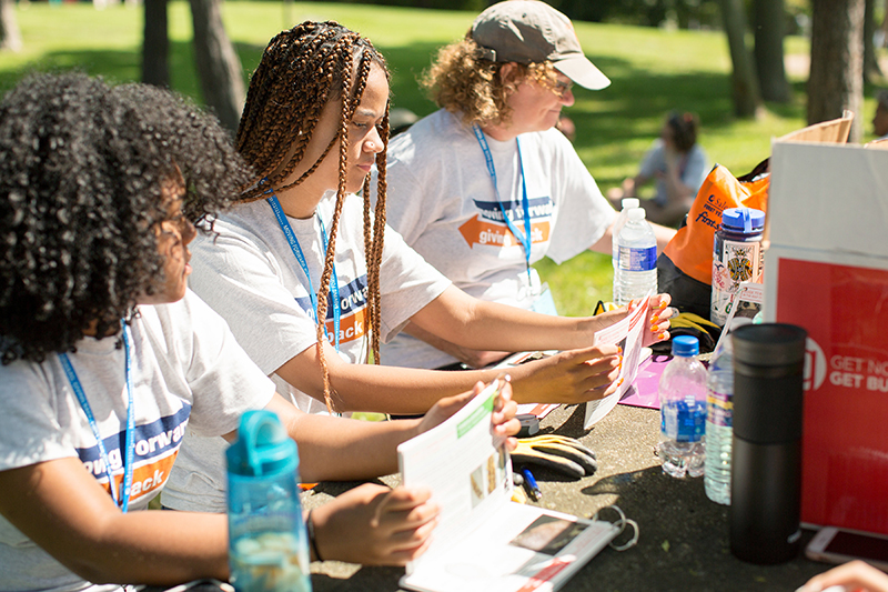 Three volunteers folding outdoors