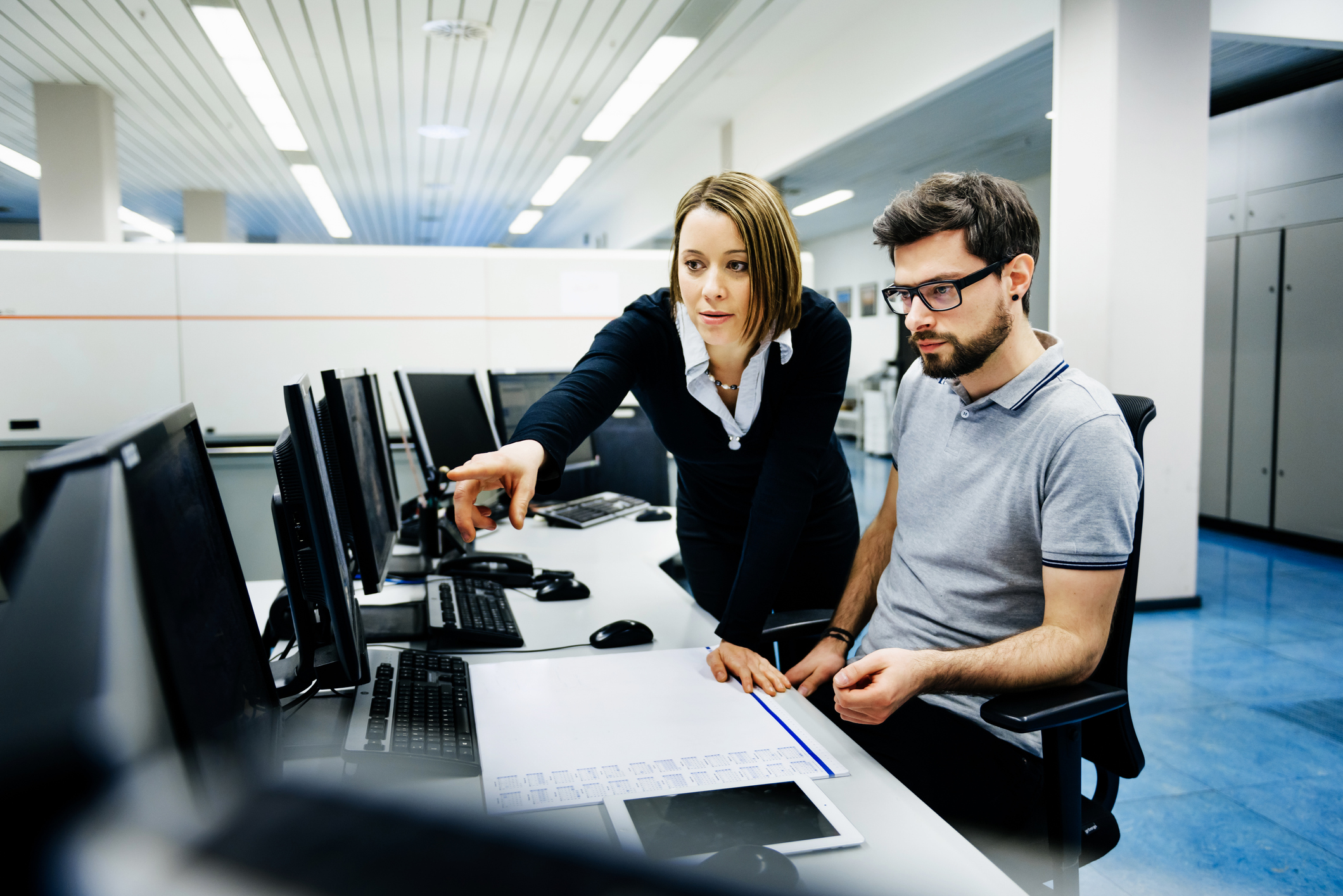 Two professionals at a computer desk