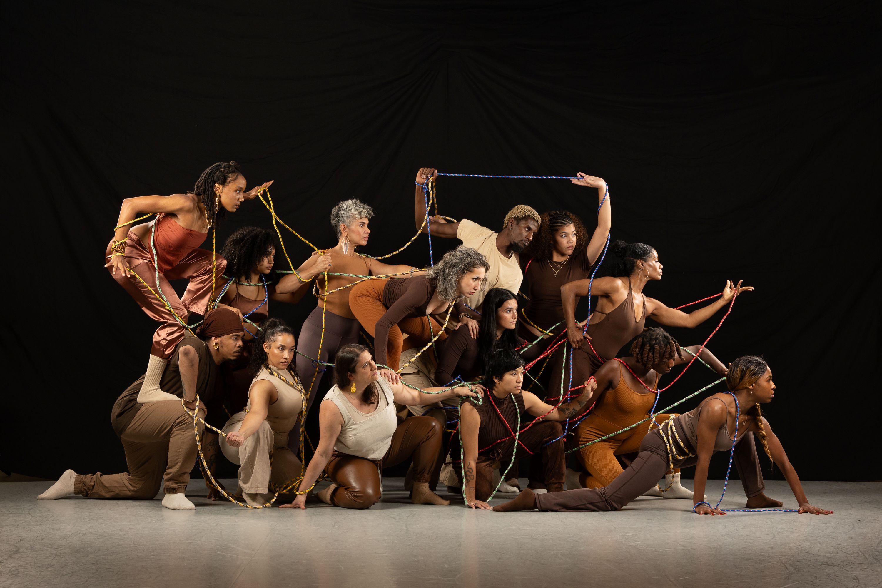 Large group of dancers facing to the right on a stage