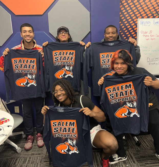 A group photo of students in the esports lounge holding up t-shirts