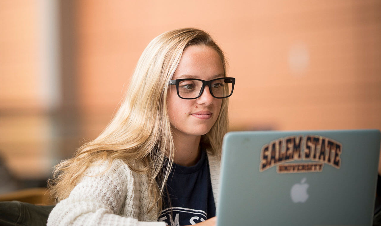 Female student on laptop in library