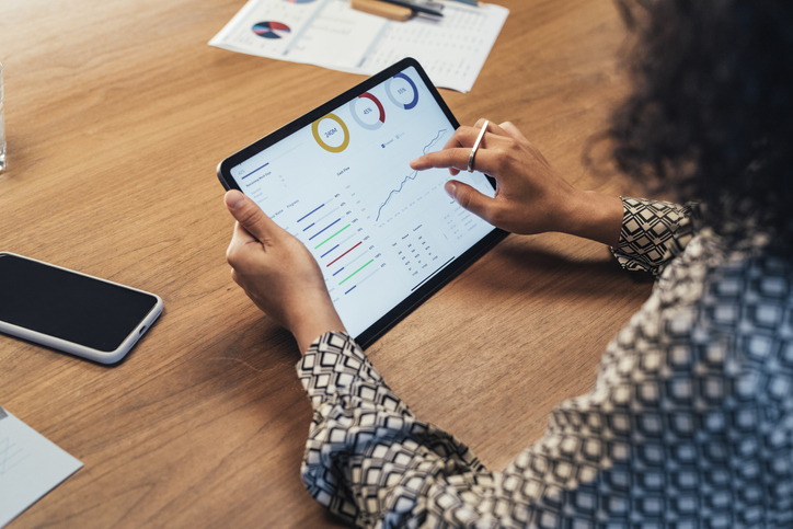 Businesswoman Analyzing Statistical Business Reports on her Tablet PC at the Office, a Close Up