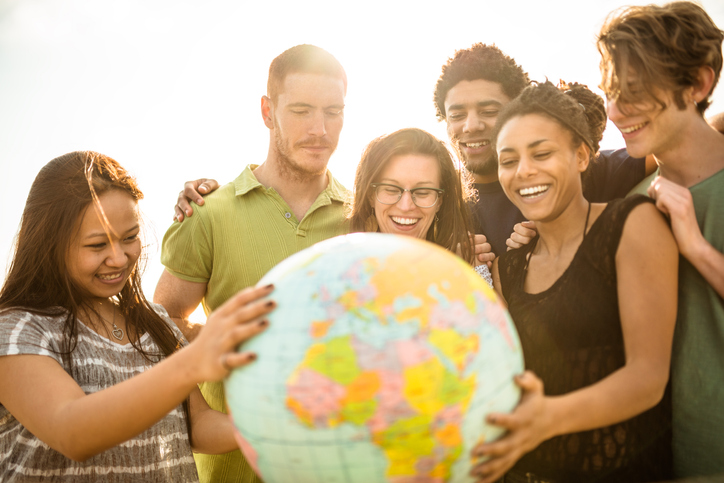 College student smiling with globe