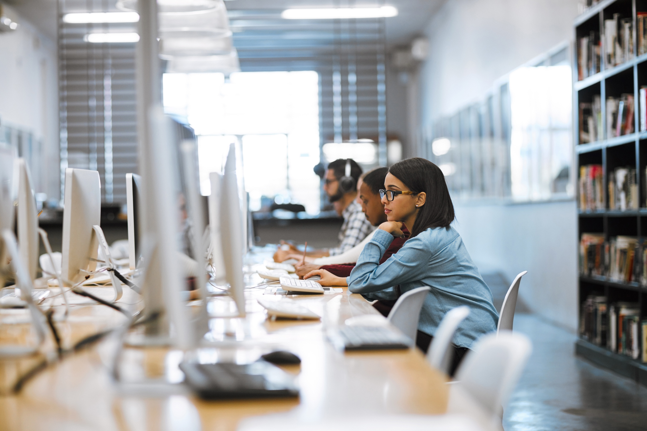 A female student works on her computer in the library