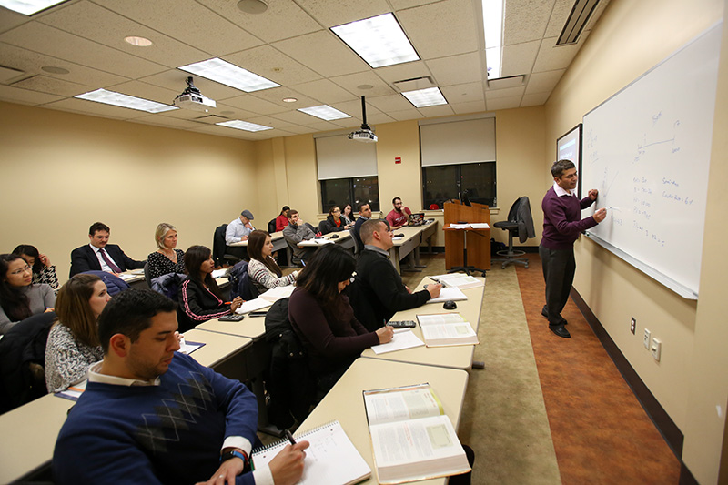 A professor at the white board with graduate students