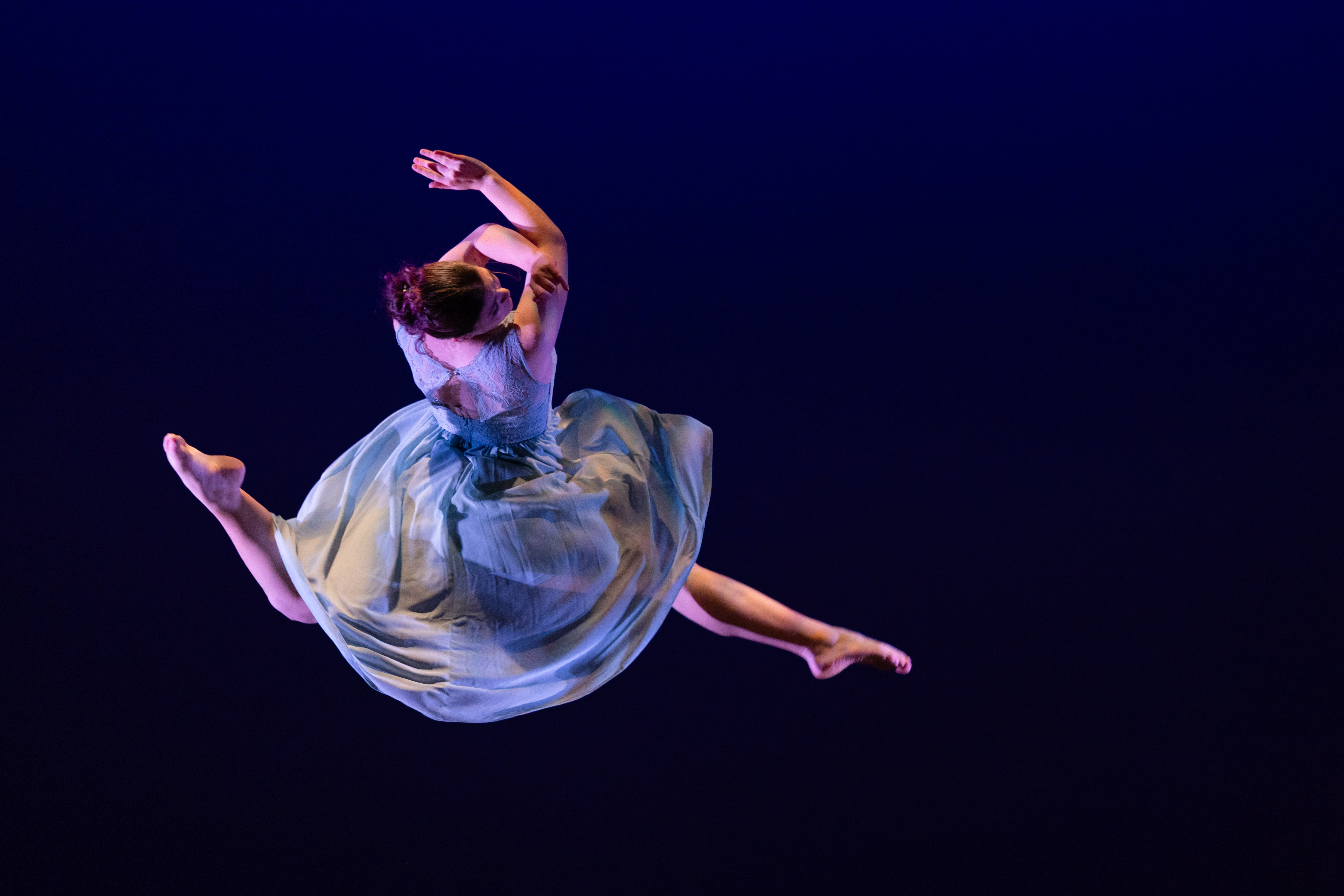 Dancer in blue spinning through the air