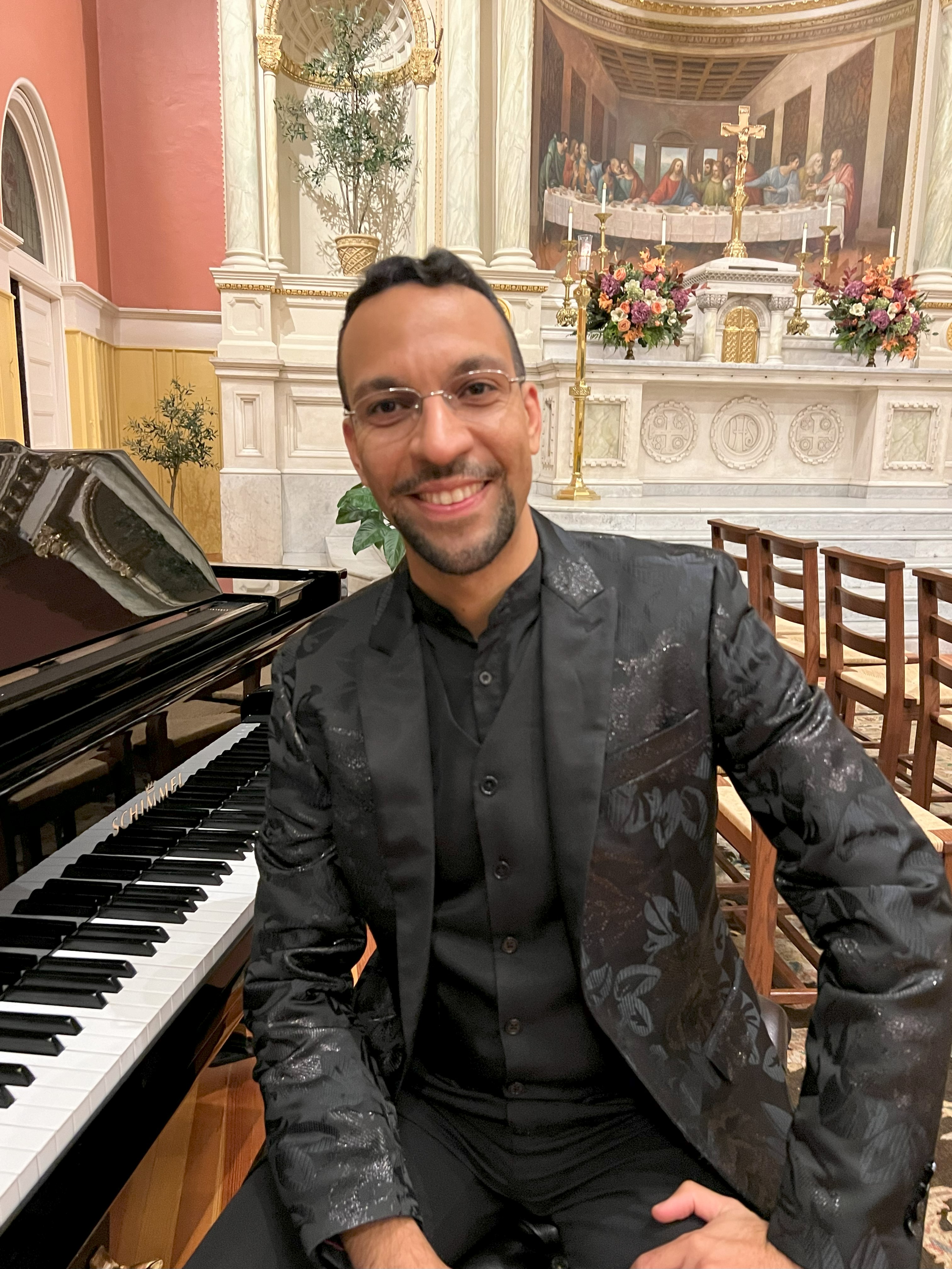 Man sitting next to a piano in a church