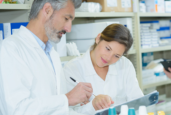 A doctor and billing assistant looking at a chart