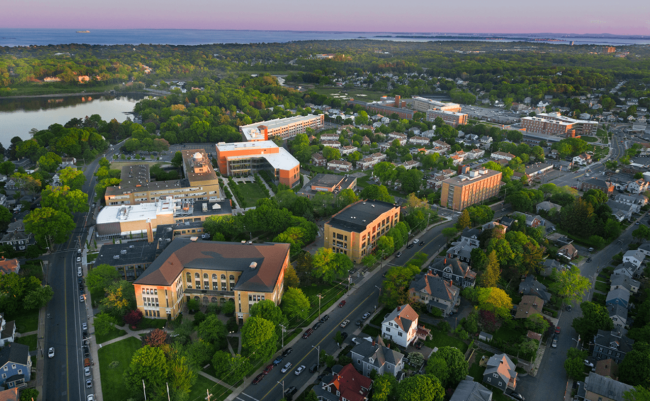 A sunset aerial view of Salem State's North Campus, which features brick buildings, trees and the streets of Salem. 