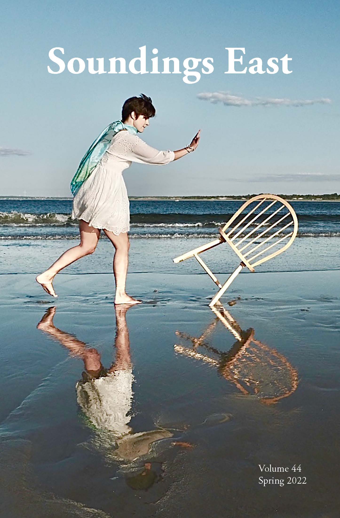 Soundings East Fall 2022 Cover: Photo of a person in a white dress pushing a white chair on the shoreline of a beach.