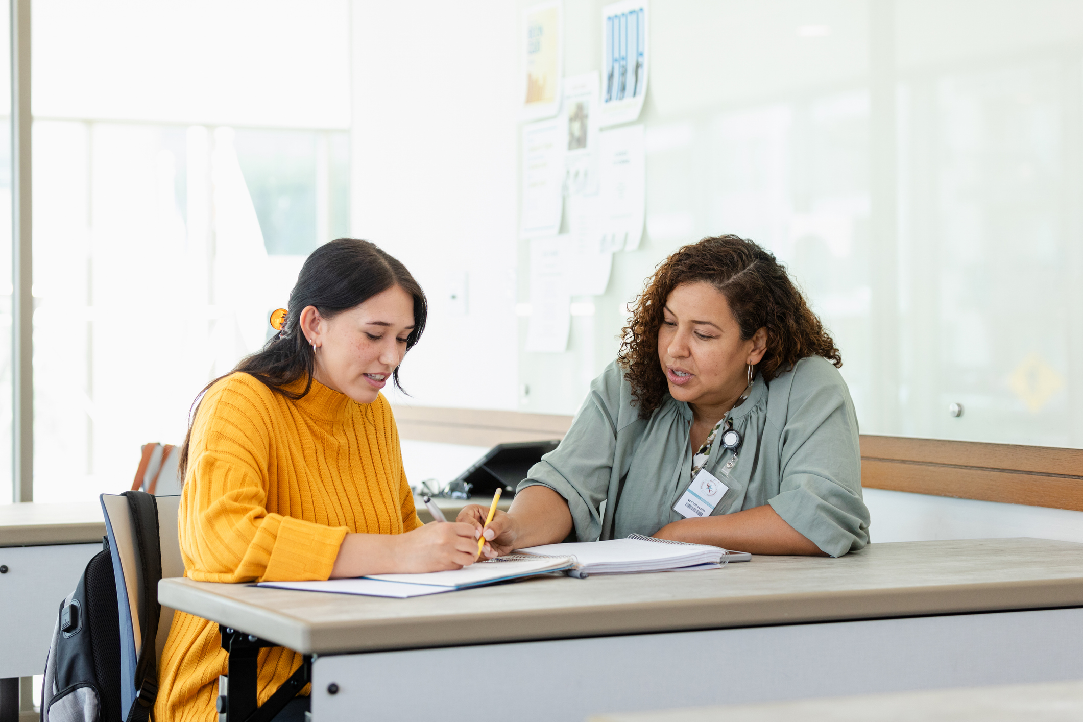 A student an staff member meeting at a desk