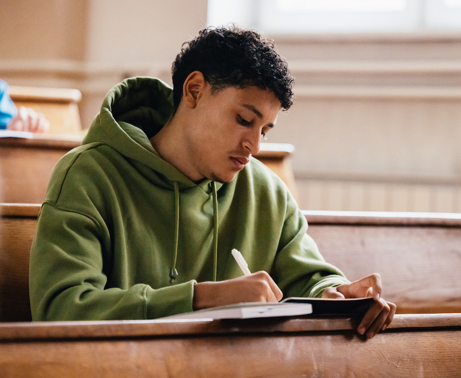 Male student taing notes in lecture hall