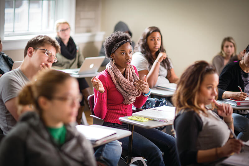 A student raises her hand in her social work class.