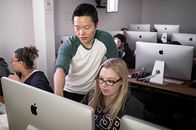 A faculty member and student at a Mac workstation