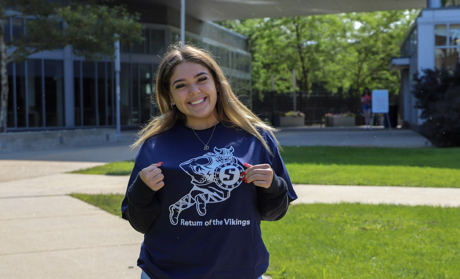 A student volunteer smiling in front of Marsh Hall