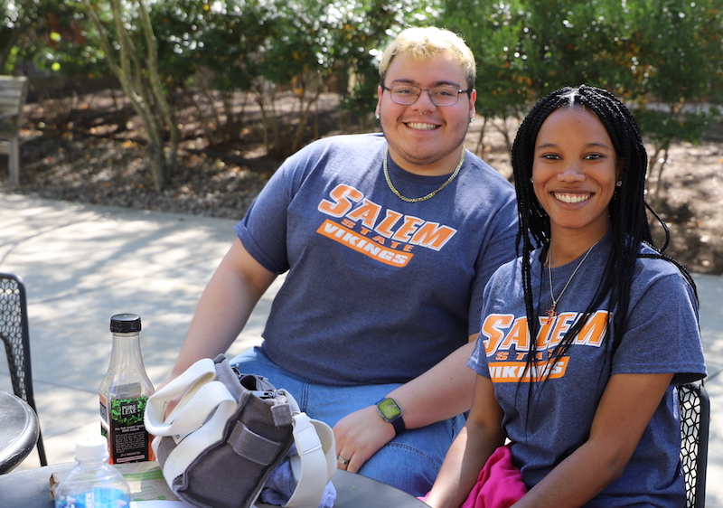 Two students in SSU t-shirts sit outside during Welcome Week