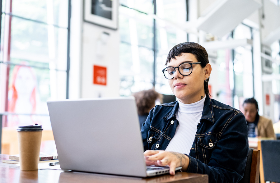 Person with coffee on computer