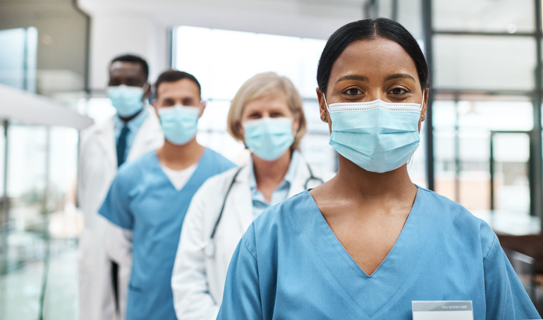 Portrait of a group of medical practitioners wearing face masks while standing together in a hospital