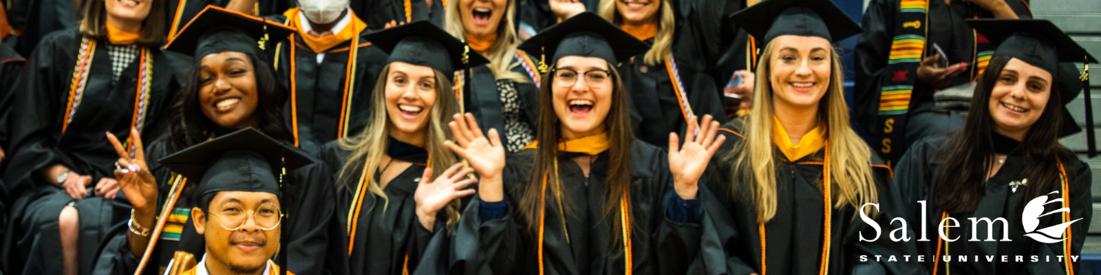 Salem State students smile at graduation.