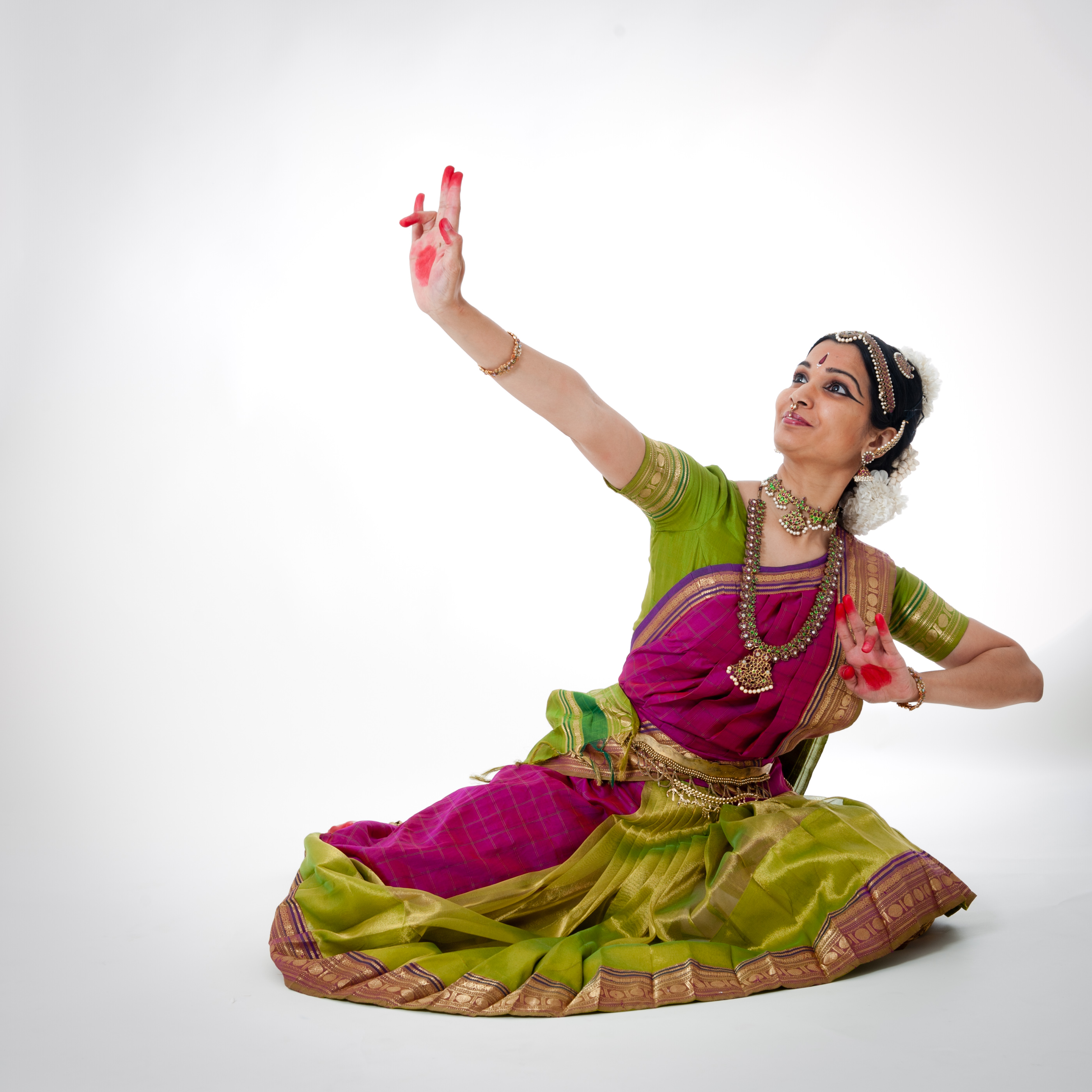 Woman in pink and green costume in a dance pose