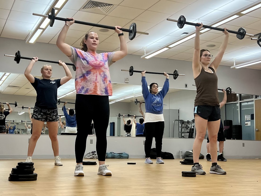 Students lifting barbells