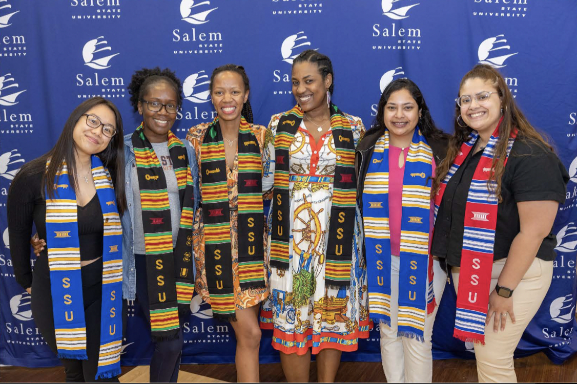 Salem State students smile for the camera in ALANA graduation cords.
