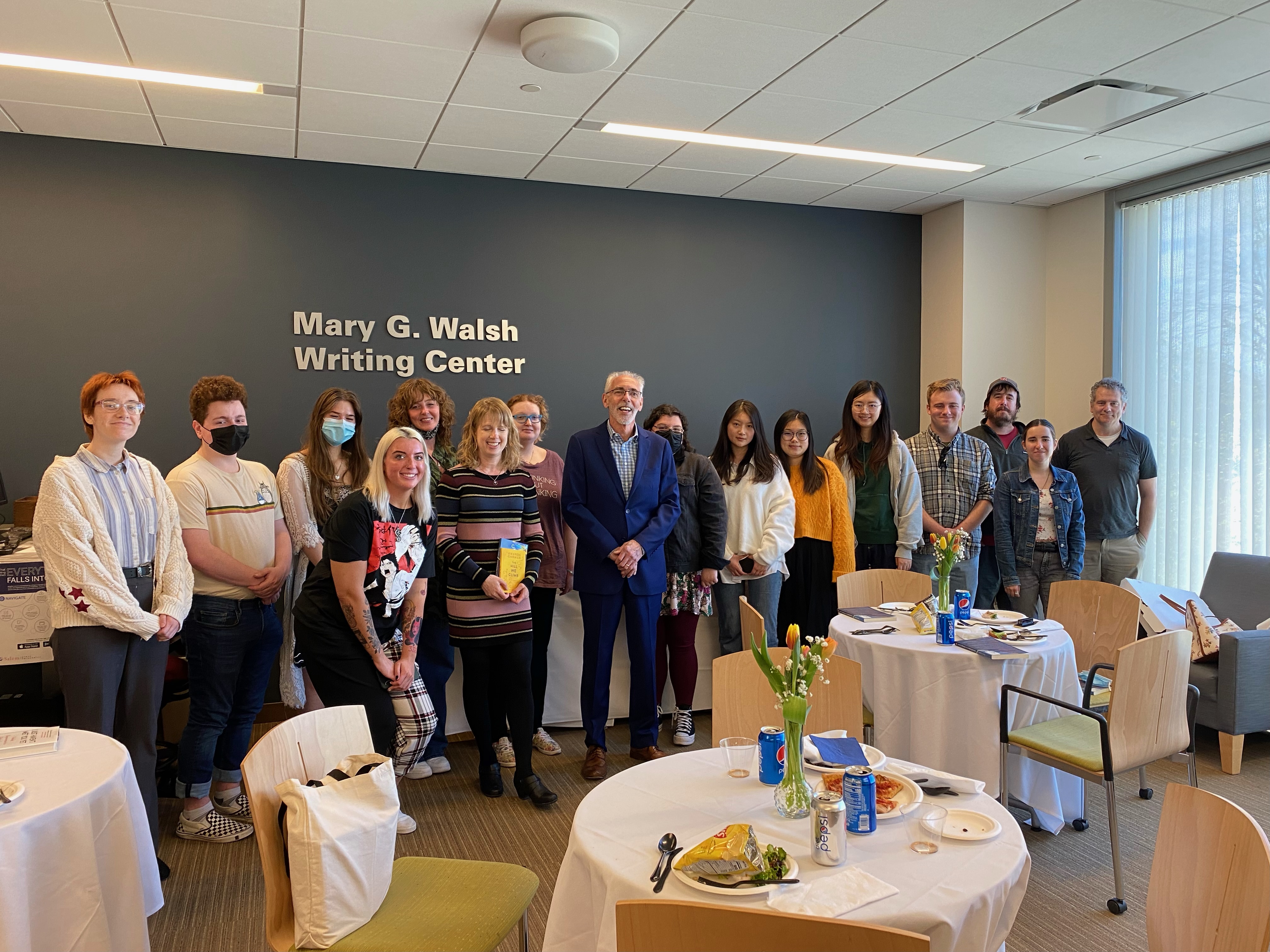 Group photo of DeCiccio standing with tutors and students in the writing center