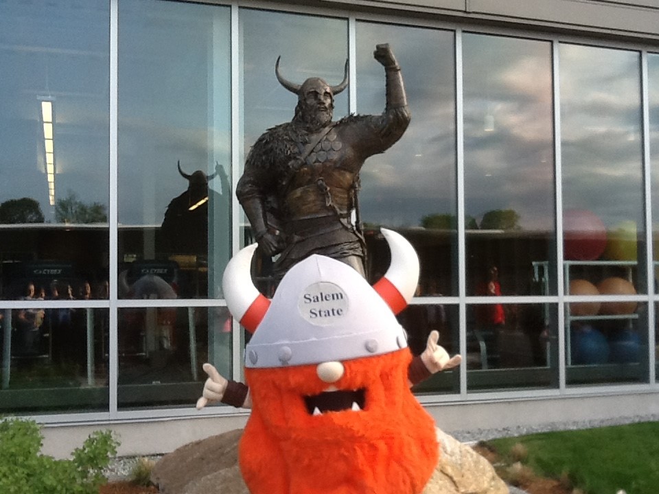 Superfan standing in front of Viking statue at Gassett Fitness Center