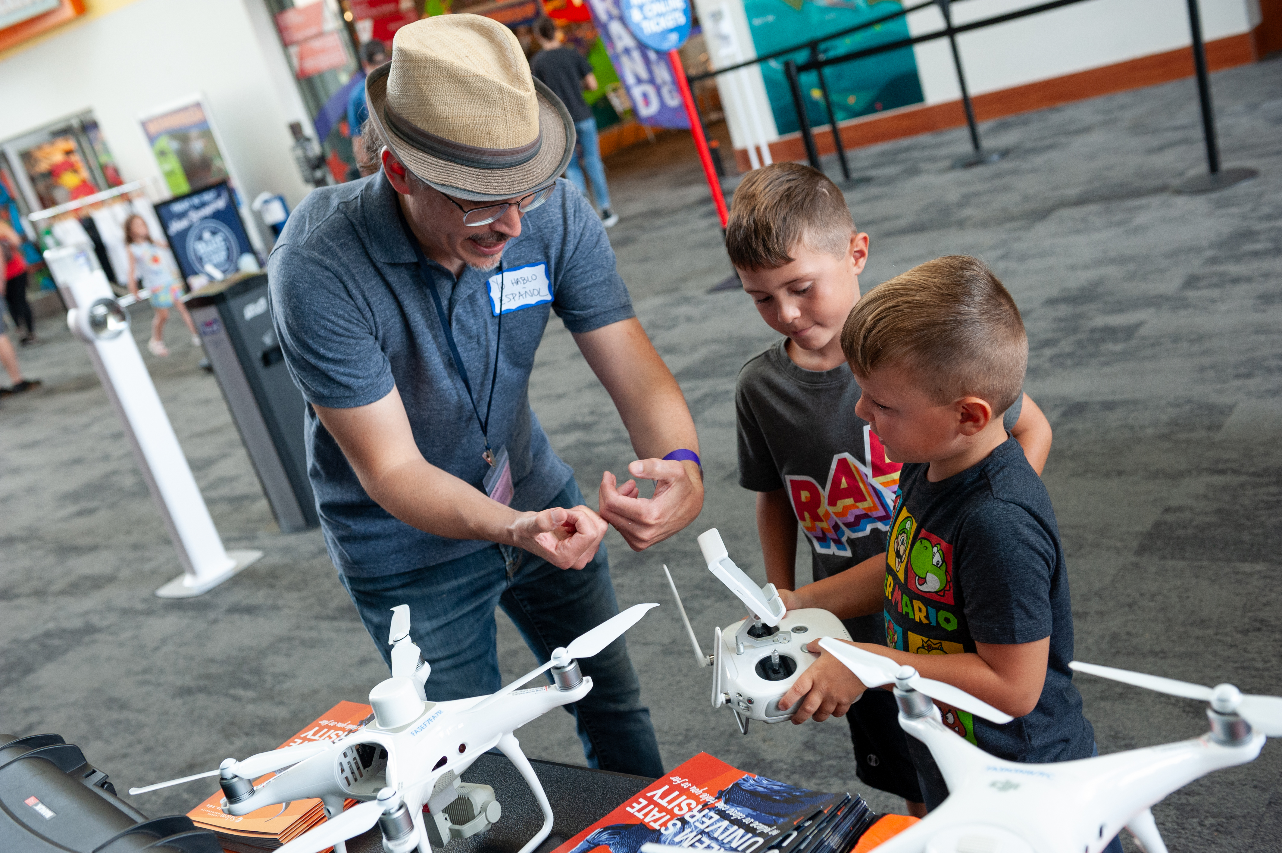 Professor Marcos Luna demonstrates how the drone controls work to visitors at C…
