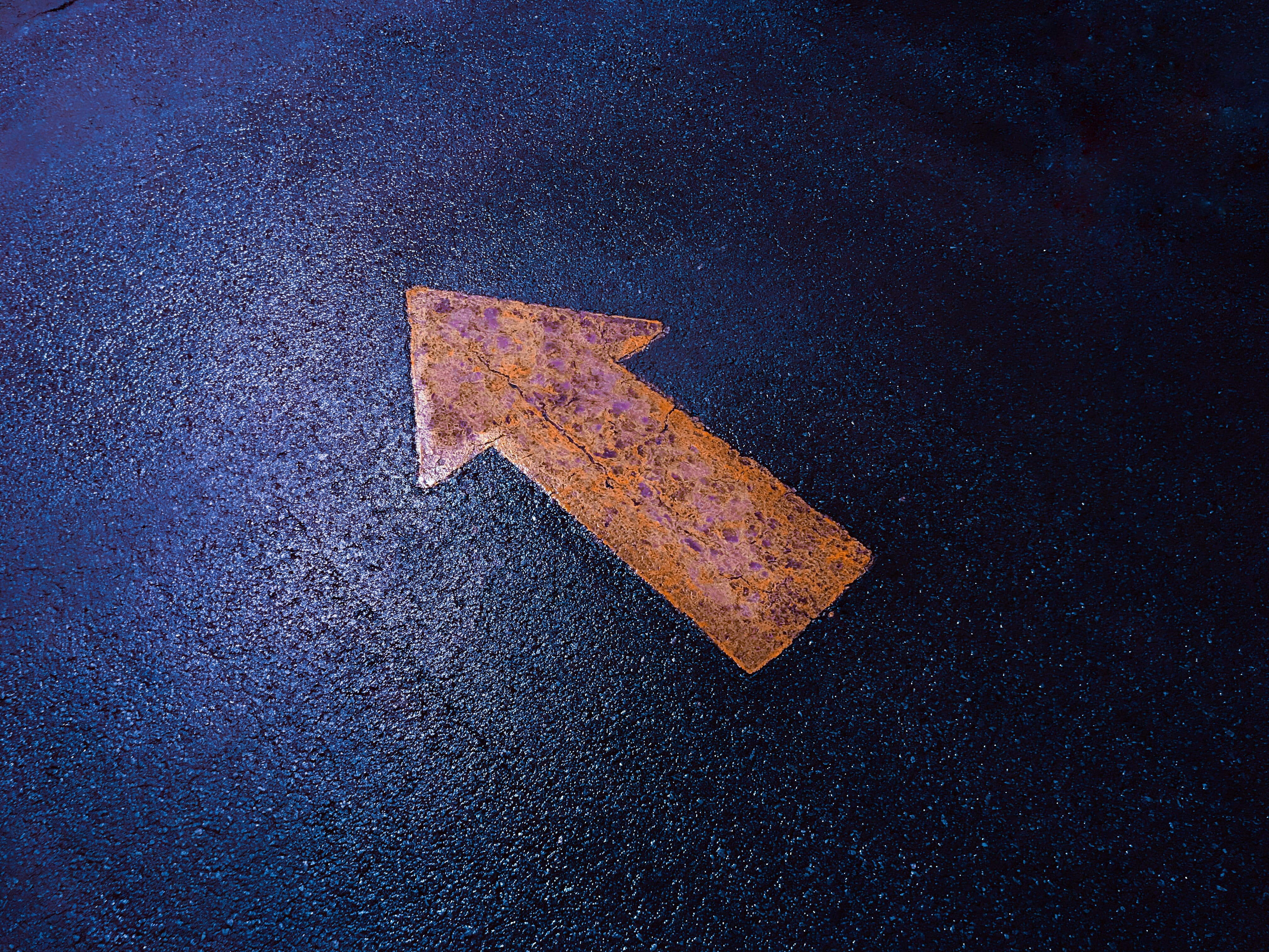 Orange arrow on a blue pavement