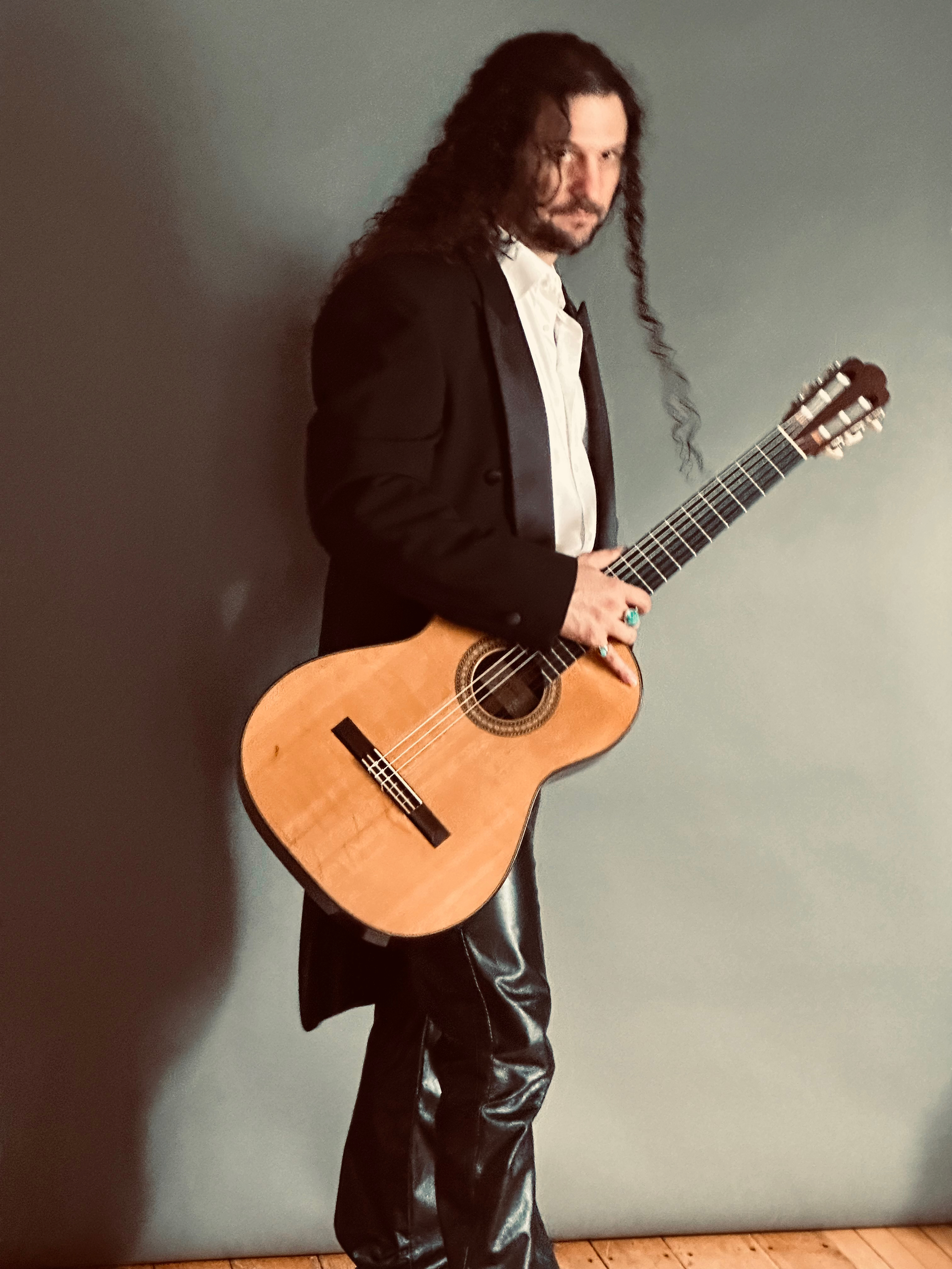 Aaron Larget-Caplan standing with guitar