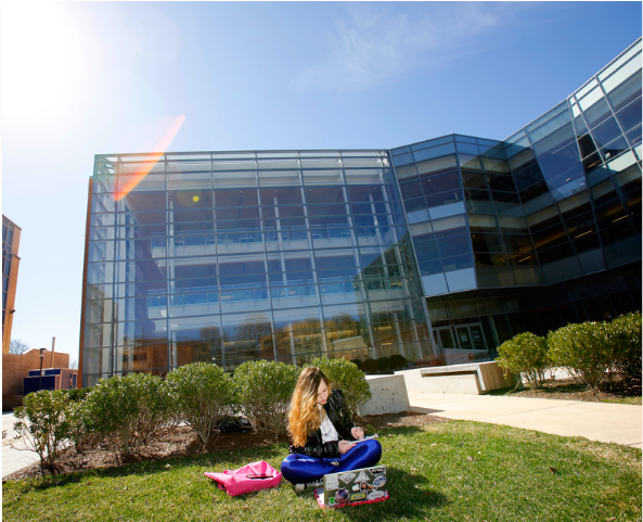 Salem State student studying in the quad in front of the Berry Library