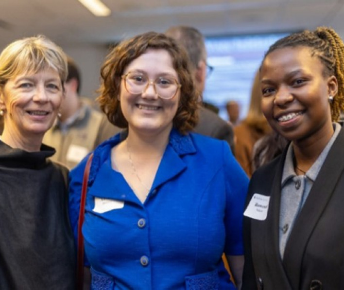 Three women smiling at a reunion event