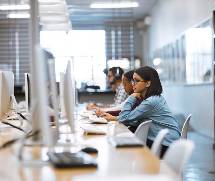 A female student works on her computer in the library