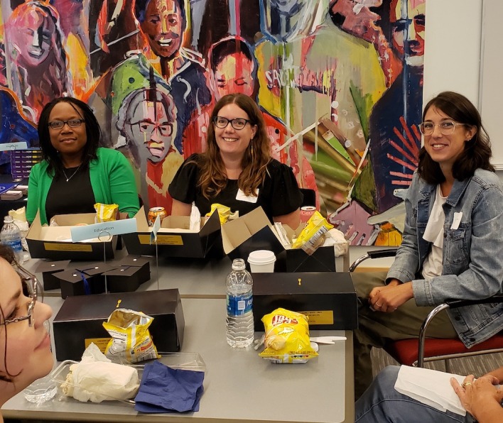 Students and faculty gather at tables during Graduate Orientation