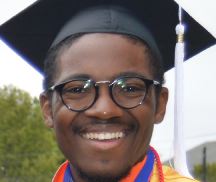 Jordan Hill wears his graduation cap and gown and smiles during the 2018 Salem State Commencement. 