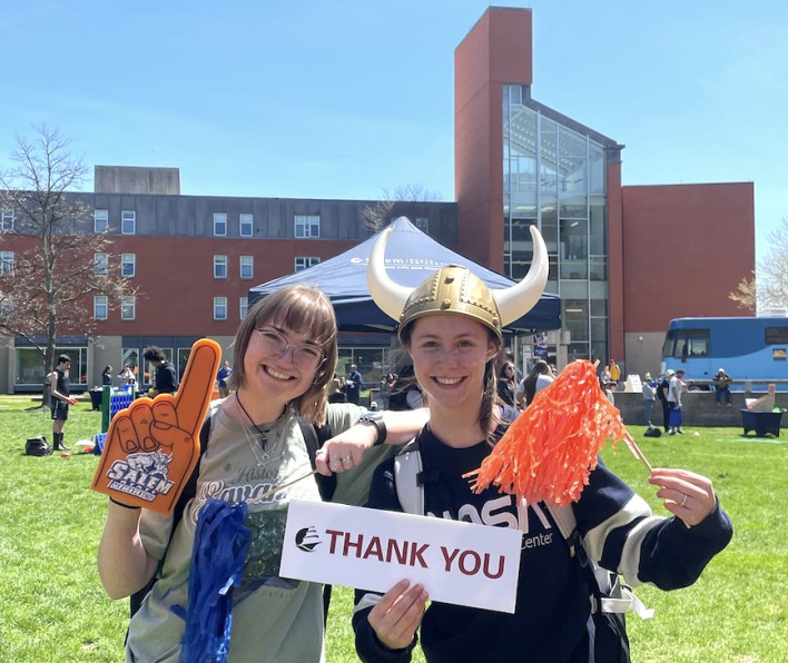 Two students with a Viking helmet and a "THANK YOU" sign in front of Atlantic Hall
