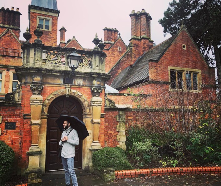 Damian Barrous-Dume stands with a black umbrella in front of the Burwalls House in London