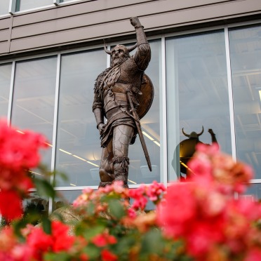 Viking statue with spring flowers beneath it