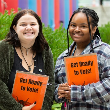 two students holding clipboards