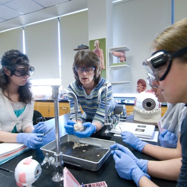 faculty with students in science lab