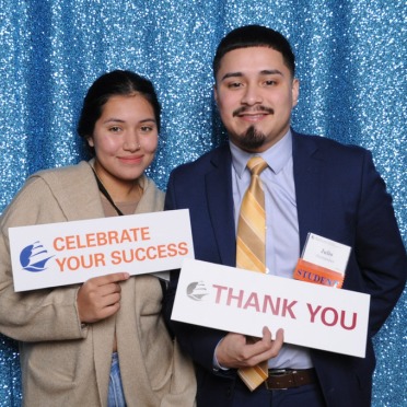 Salem State student at the scholar and donor celebration holding a sign that reads thank you