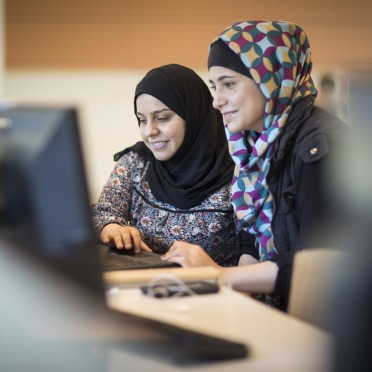 Two students in front of a computer