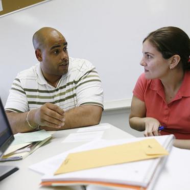 Faculty member and student working together in front of a computer