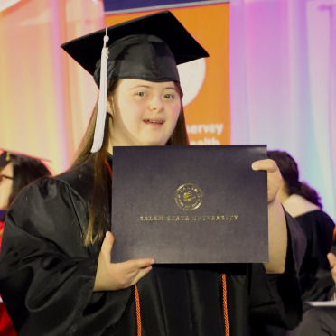 A Community of Inclusive Scholars graduate receiving her certificate of completion at Commencement