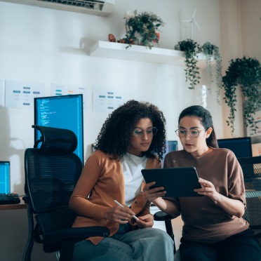 Two people looking at a shared iPad in an office