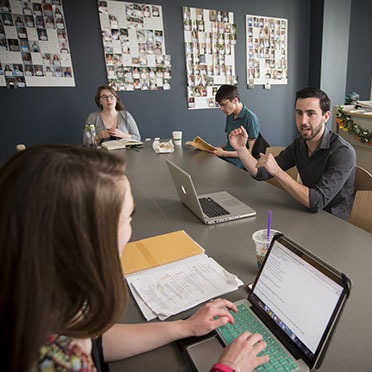 A group of honor students work together at a conference table